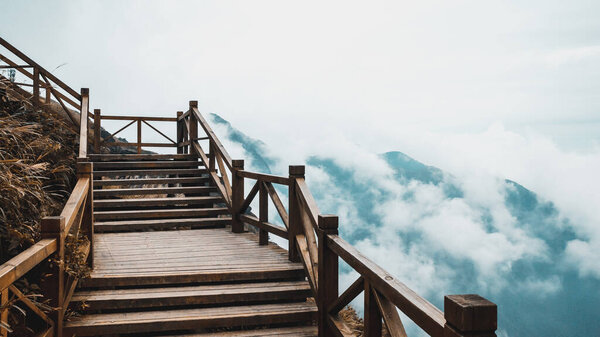 Wooden walking path with view of mountain covered by clouds on Wugong Mountain in Jiangxi, China
