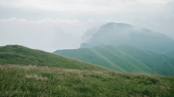 Grassland on mountain ridge covered in clouds on top of Wugong Mountain in Jiangxi, China