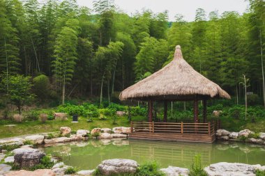 Shaoxing, Çin 'deki Lanting (Orkide Pavyonu) manzaralı gölet kenarındaki kulübe