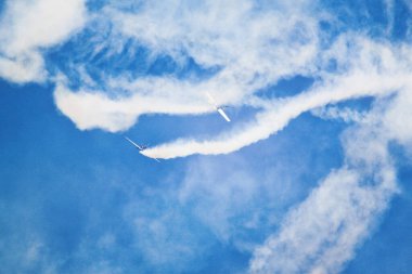 Gökyüzünde yükselen ve duman çıkaran savaş uçağı mavi gökyüzüne ve dumana karşı bu görüntüleri fotoğrafladı..