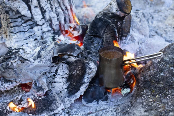 Cooking coffee on a fire. Make coffee or tea on the fire of nature. Burned fire. Place for the fire. Ash and coals and ash from the fire.