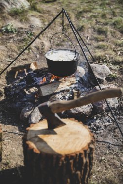 Bir ateş üzerinde pişirme. Balık çorbası bir yanıyor. Yiyecek bir kazan bir yanıyor. Gıda açık havada. Açık havada yemek. Kazan üzerinde doğada yemek.