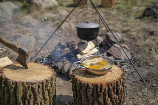 Cooking on a fire. Fish soup on a fire. Food in a cauldron on a fire. Food outdoors. Cooking outdoors. Cooking in nature on the cauldron.