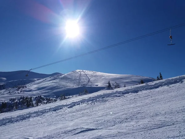 Salida del sol en las montañas nevadas. Montañas Cárpatas en la nieve. Teleférico . — Foto de Stock