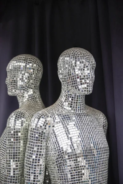 Mannequin head. Mannequin covered with slices of a mirror on a black background.