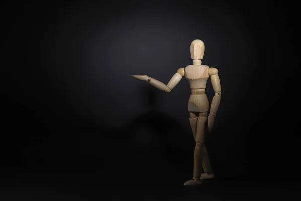 A wooden mannequin shows with his hand. The concept of pointing at someone with your finger. The mannequin will stretch out his hand. Wooden man concept. Wooden mannequin