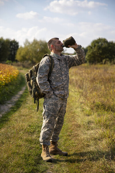 The soldier holds a flask