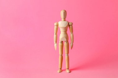 Pembe arka planda tahta bir manken. Tahta adam. Ahşap manken.