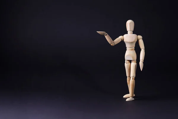 A wooden mannequin shows with his hand. The concept of pointing