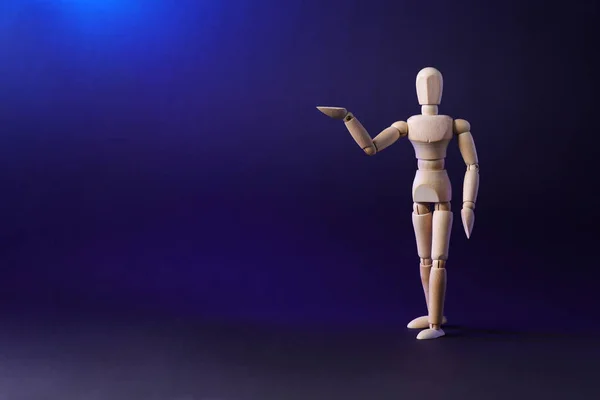 A wooden mannequin shows with his hand. The concept of pointing