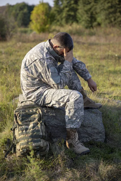 Soldaten sitter och vilar. Sorglig soldat. Trött soldat. — Stockfoto