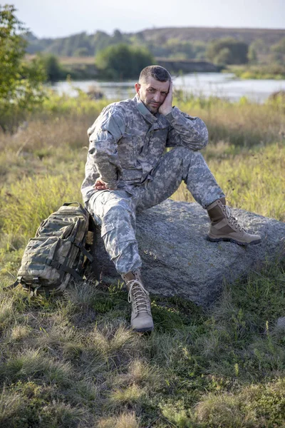 Soldaten sitter och vilar. Sorglig soldat. Trött soldat. — Stockfoto