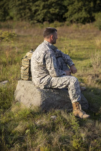 Soldaten sitter och vilar. Ledsen och trött soldat. Soldat — Stockfoto