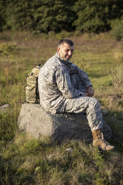 Soldaten sitter och vilar. Ledsen och trött soldat. Soldat — Stockfoto