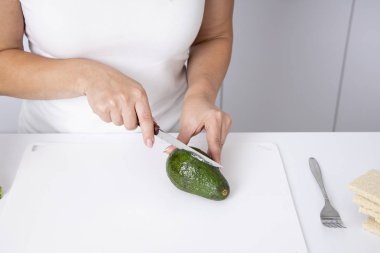 Kız elinde bir avokado tutuyor. T taze avokado kesme Kadın