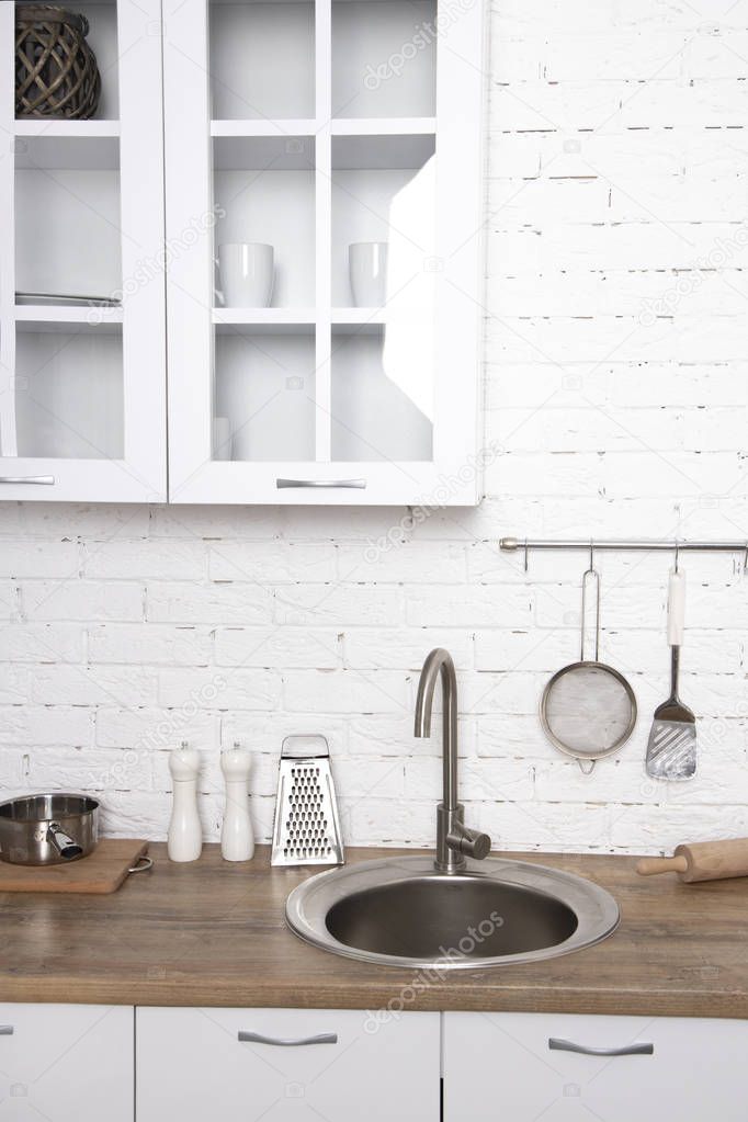 Interior of minimalistic kitchen with white walls, white furnitu