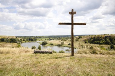 Arka planda parlak güneş ve bulutlar ile Haç. Ahşap cro