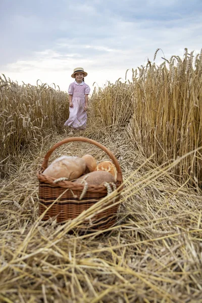 Holčička, která drží kolem chleba. Ruce drží velký chléb. Pekárny — Stock fotografie