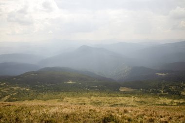 Mavi gökyüzüne karşı dağların ve ormanların güzel manzarası