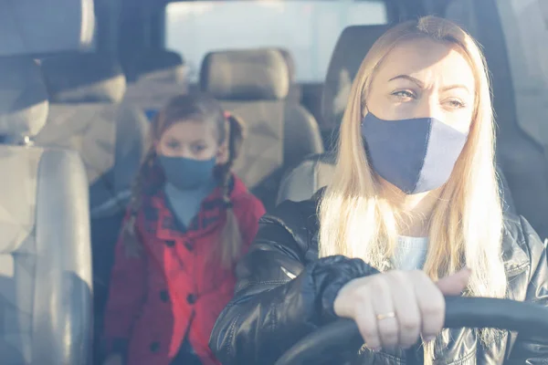 Woman wearing surgical mask in the car, for corona virus or Covid-19 protection.
