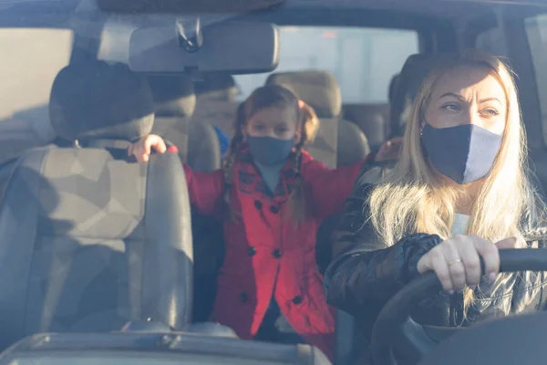 Woman wearing surgical mask in the car, for corona virus or Covid-19 protection.