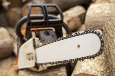 Tahta keserken elektrikli testere. Testereyle odun kesen adam, toz ve hareketler. Elektrikli testere. Tahta kesicinin yakın plan testeresi hareket halinde, talaş yana doğru uçuyor..