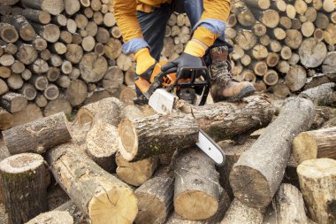 Tahta keserken elektrikli testere. Testereyle odun kesen adam, toz ve hareketler. Elektrikli testere. Tahta kesicinin yakın plan testeresi hareket halinde, talaş yana doğru uçuyor..