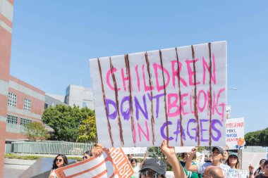 Los Angeles, 30 Haziran 2018: Büyükşehir gözaltı merkezi başkanı Donald Trump'ın sıfır tolerans Göçmenlik politikası protesto etrafında bir işaret sırasında ailelere ait birlikte Mart bir aktivist tutar.