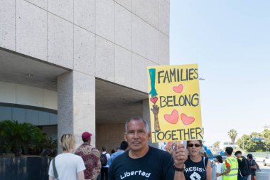 Los Angeles, 30 Haziran 2018: Büyükşehir gözaltı merkezi başkanı Donald Trump'ın sıfır tolerans Göçmenlik politikası protesto etrafında bir işaret sırasında ailelere ait birlikte Mart bir aktivist tutar.