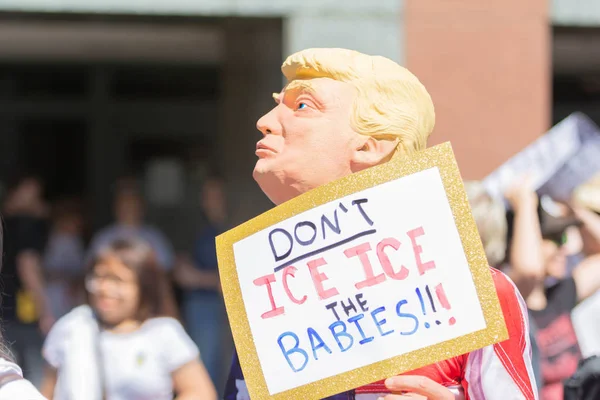 Los Angeles, 30 Haziran 2018: aileler ait birlikte Mart çevresinde Büyükşehir gözaltı merkezi başkanı Donald Trump'ın sıfır tolerans Göçmenlik politikası protesto sırasında Donald Trump maskeli bir aktivist.