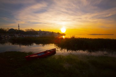 Gölyazı'daki Uluabat Gölü'nde balıkçılar tekneden göle balık ağı atıyor