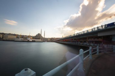 Gün batımında İstanbul Cityscape - kırmızı Türk bayrağı ve Haliç üzerinde uçan martılar ile buharlı tekne. Beyoğlu'nda Galata kulesi yakınındaki eski kentin panoraması, Karaköy'ün iniş sahnesine bak.