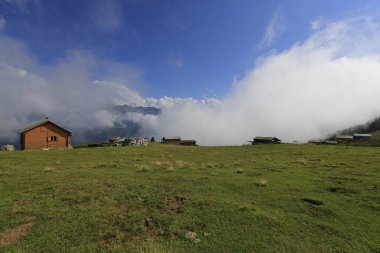 Rize'nin Pokut Yaylası'nda köy evleri, bulutlar ve yeşil çimenler. Karadeniz Bölgesi.