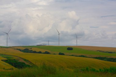 Mavi gökyüzünde dağda tarlada duran vahşi değirmen