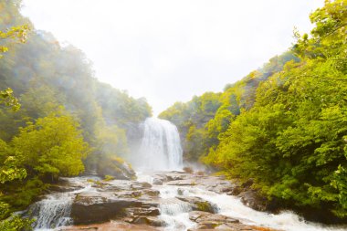 Mustafa Kemal Paşa'da Suuctu şelaleleri, Bursa, Türkiye. Ağaçlar arasında güzel şelale, yeşil yapraklar, kayalar ve nehir arka plan ile gizli ormanda taşlar.
