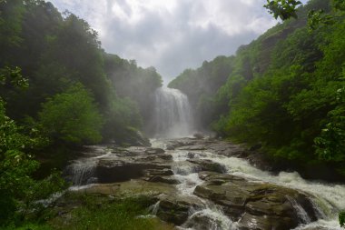 Mustafa Kemal Paşa'da Suuctu şelaleleri, Bursa, Türkiye. Ağaçlar arasında güzel şelale, yeşil yapraklar, kayalar ve nehir arka plan ile gizli ormanda taşlar.