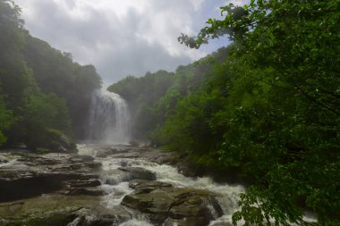 Mustafa Kemal Paşa'da Suuctu şelaleleri, Bursa, Türkiye. Ağaçlar arasında güzel şelale, yeşil yapraklar, kayalar ve nehir arka plan ile gizli ormanda taşlar.