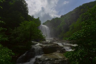 Mustafa Kemal Paşa'da Suuctu şelaleleri, Bursa, Türkiye. Ağaçlar arasında güzel şelale, yeşil yapraklar, kayalar ve nehir arka plan ile gizli ormanda taşlar.