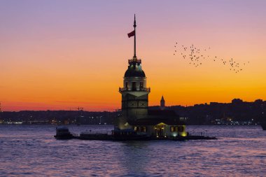 İstanbul, Türkiye 'nin sembolü Leander' s Tower olarak da bilinen ünlü Maiden 's Tower (Kiz Kulesi) ile Boğaz' ın üzerinde kızgın bir günbatımı. Duvar kağıdı veya rehber kitap için sahne yolculuğu arkaplanı