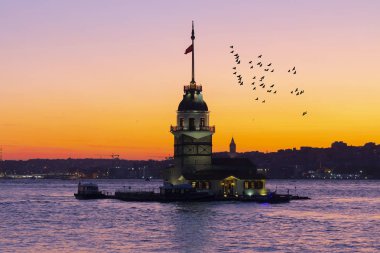 İstanbul, Türkiye 'nin sembolü Leander' s Tower olarak da bilinen ünlü Maiden 's Tower (Kiz Kulesi) ile Boğaz' ın üzerinde kızgın bir günbatımı. Duvar kağıdı veya rehber kitap için sahne yolculuğu arkaplanı