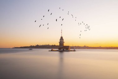 İstanbul, Türkiye 'nin sembolü Leander' s Tower olarak da bilinen ünlü Maiden 's Tower (Kiz Kulesi) ile Boğaz' ın üzerinde kızgın bir günbatımı. Duvar kağıdı veya rehber kitap için sahne yolculuğu arkaplanı