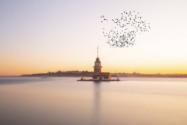 İstanbul, Türkiye 'nin sembolü Leander' s Tower olarak da bilinen ünlü Maiden 's Tower (Kiz Kulesi) ile Boğaz' ın üzerinde kızgın bir günbatımı. Duvar kağıdı veya rehber kitap için sahne yolculuğu arkaplanı