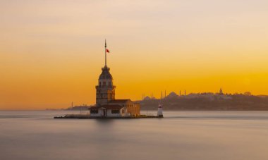 Gün batımında doğudan İstanbul Kız Kulesi. Uzaklıkta Sultanahmet Camii, Ayasofya ve Topkapı Sarayı gibi simge yapılar bulunmaktadır.