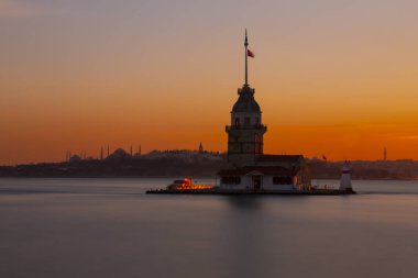 Gün batımında doğudan İstanbul Kız Kulesi. Uzaklıkta Sultanahmet Camii, Ayasofya ve Topkapı Sarayı gibi simge yapılar bulunmaktadır.