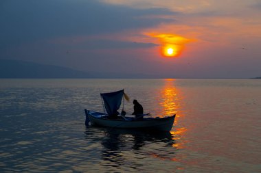 Siluet Balıkçı teknede balık ağları.