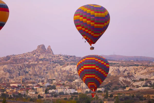 Hot air balloon flying over spectacular Cappadocia - Girls watching hot air balloon at the hill of Cappadocia