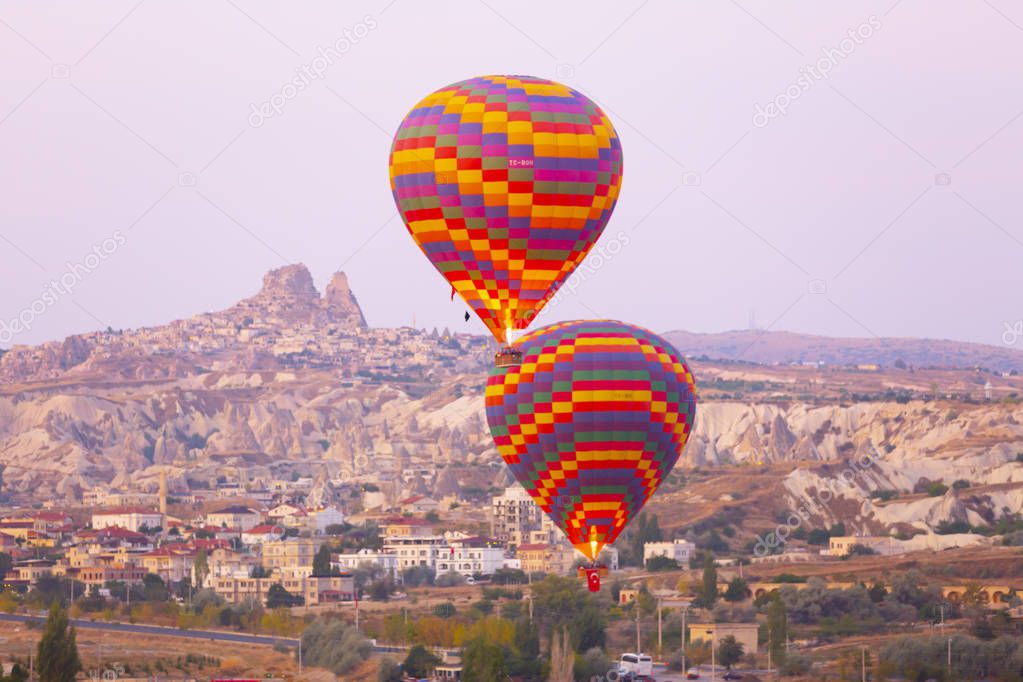 Hot air balloon flying over spectacular Cappadocia - Girls watching hot air balloon at the hill of Cappadocia