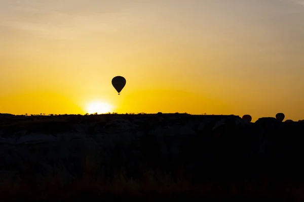 壮大なカッパドキアの上を飛ぶ熱気球 カッパドキアの丘で熱気球を見ている女の子 — ストック写真