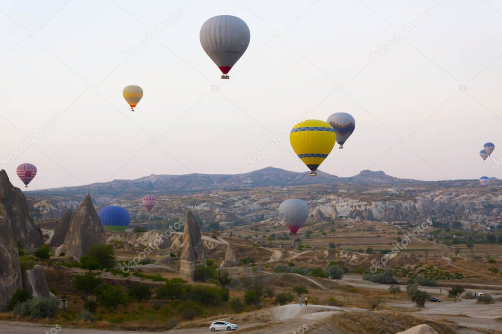 Hot air balloon flying over spectacular Cappadocia - Girls watching hot air balloon at the hill of Cappadocia
