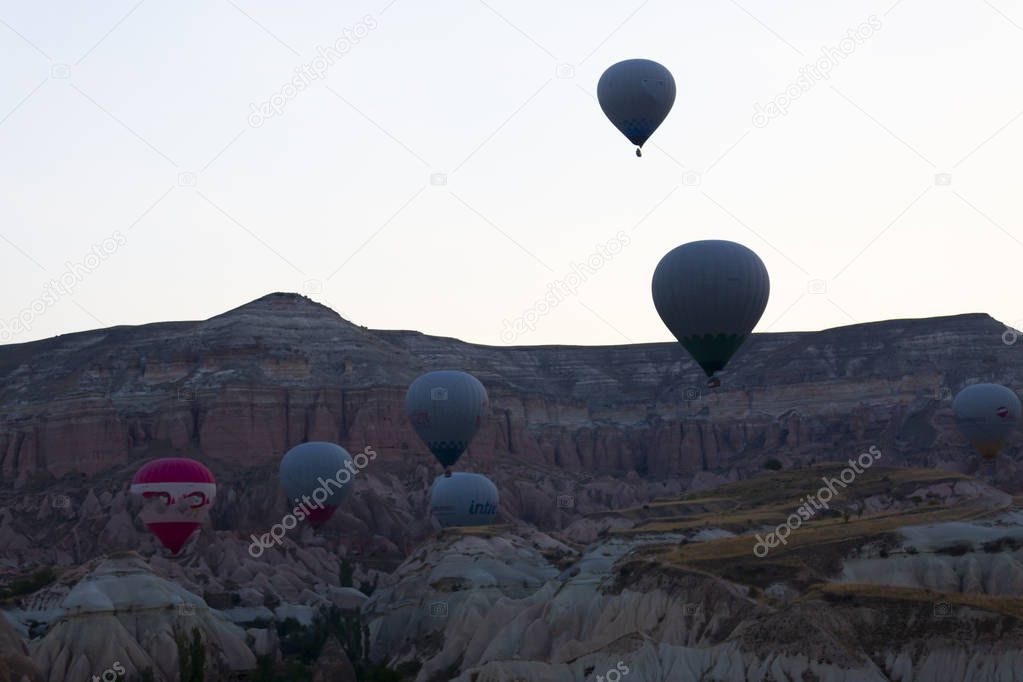 Hot air balloon flying over spectacular Cappadocia - Girls watching hot air balloon at the hill of Cappadocia